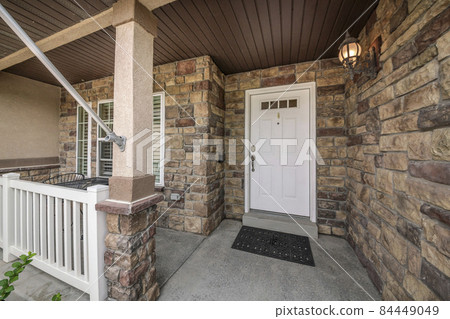 Front exterior of a house with white door and stone walls Front exterior of a house with white door and stone walls 84449049