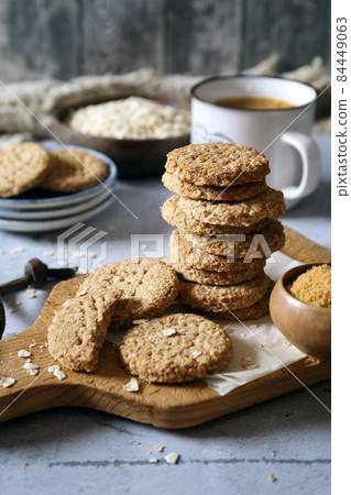 Crispy oatmeal cookies with unrefined brown sugar and cup of coffee 84449063