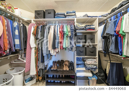 Organized small walk in wardrobe with clothes and linen storage boxes Organized small walk in wardrobe with clothes and linen storage boxes 84449068