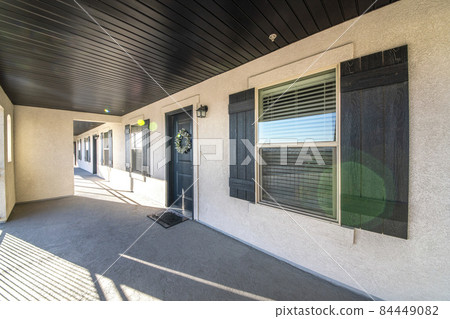 Front exterior of an apartment door with concrete flooring 84449082