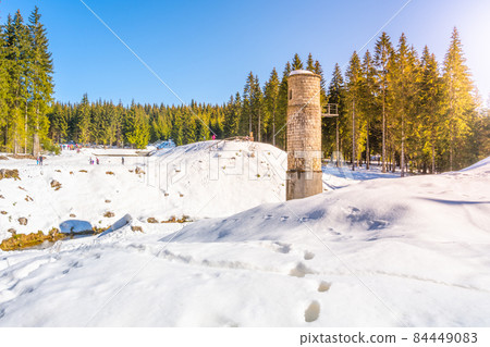 Broken dam in winter mountains 84449083