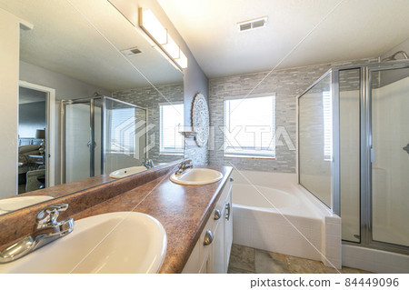 Master bathroom with a warm lightning and stone tile walls 84449096