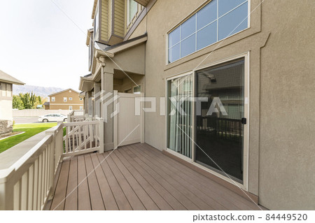 Exterior of a house on a wooden deck with sliding glass door Exterior of a house on a wooden deck with sliding glass door 84449520