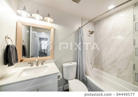 Small bathroom interior with single vanity sink and shower tub with tile walls Small bathroom interior with single vanity sink and shower tub with tile walls 84449577