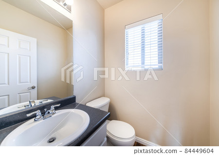 Powder room interior with black marble countertop and window 84449604