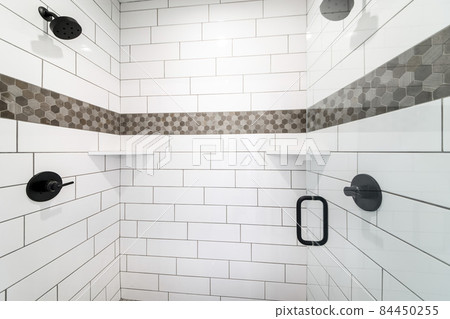 Shower stall with decorative tile walls outline and opened transparent glass door Shower stall with decorative tile walls outline and opened transparent glass door 84450255