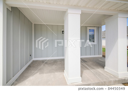 Exterior of a house with wood sidings and two white column posts 84450349