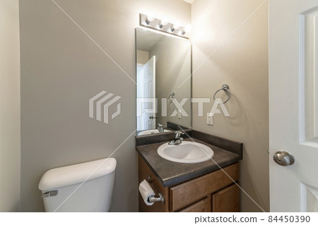 Small space powder room with toilet bowl and vanity sink 84450390