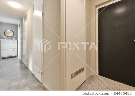 Long stylish corridor with a black entrance door 84450493