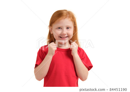Cheerful little girl, look so excited she is raising her fists up, isolated on white background. 84451190