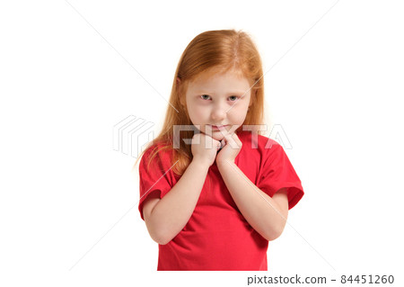 Portrait of cheerful caucasian little girl with red hair posing in studio with looking to the camera. Portrait of cheerful caucasian little girl with red hair posing in studio with looking to the camera. 84451260