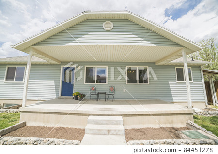 Pastel colored house entrance exterior with stairs, plants and windows 84451278