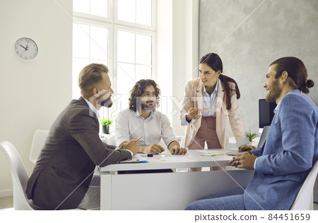 Group of people meeting around office table, working on new project or discussing important business deal. Male colleagues listening to female team manager stating her point of view in work meeting 84451659