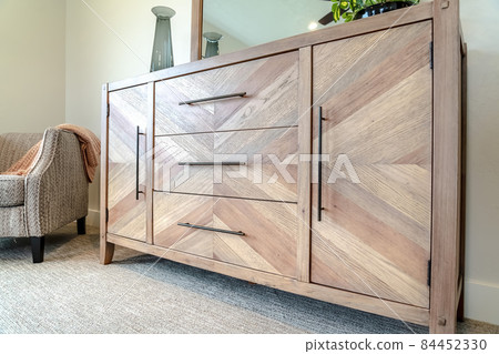 Wooden vanity cabinet and upholstered armchair inside the bedroom of home Wooden vanity cabinet and upholstered armchair inside the bedroom of home 84452330