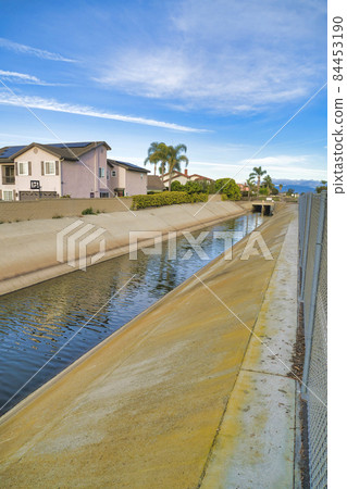 Storm drain with rain and ground water from the streets of the neighborhood 84453190