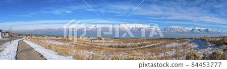 A panoramic view of the snowy wasatch mountains with the clear blue sky in the background A panoramic view of the snowy wasatch mountains with the clear blue sky in the background 84453777