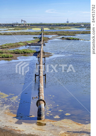 Rusty pipe of an oil rig over wetland water at Bolsa Chica Ecological Reserve 84453782