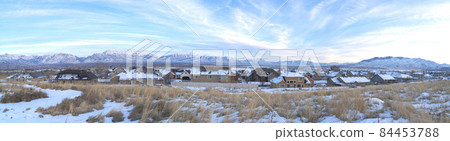 A panoramic view of houses with the mountains in the background 84453788