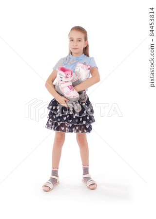 Happy little girl holds in hands roller skates 84453814