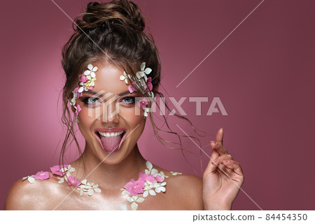 Beautiful caucasian woman with flowers on pink background. 84454350