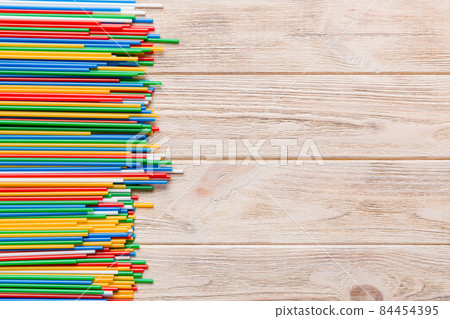 Heap of colorful plastic drinking straws on Colored background, flat lay. Copy Space for text Heap of colorful plastic drinking straws on Colored background, flat lay. Copy Space for text 84454395