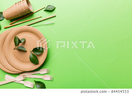 set of empty reusable disposable eco-friendly plates, cups, utensils on light white colored table background. top view. Biodegradable craft dishes. Recycling concept. Close-up set of empty reusable disposable eco-friendly plates, cups, utensils on light white colored table background. top view. Biodegradable craft dishes. Recycling concept. Close-up 84454553
