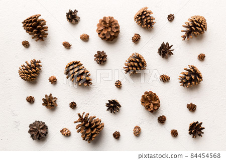 pine cones on colored table. natural holiday background with pinecones grouped together. Flat lay. Winter concept pine cones on colored table. natural holiday background with pinecones grouped together. Flat lay. Winter concept 84454568