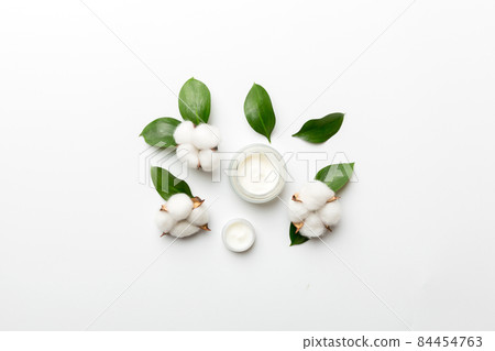 Organic cosmetic products with cotton flower and green leaves on white background. Flat lay Organic cosmetic products with cotton flower and green leaves on white background. Flat lay 84454763