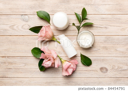 Composition with cosmetic products and beautiful roses on wooden background. Flat lay 84454791