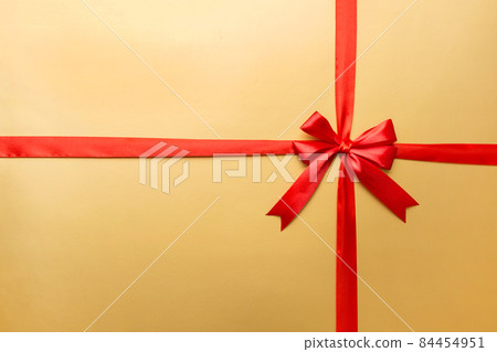 Top view of Red ribbon rolled and red bow isolated on colored background. Flat lay with copy space 84454951