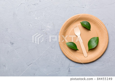 set of empty reusable disposable eco-friendly plates, cups, utensils on light white colored table background. top view. Biodegradable craft dishes. Recycling concept. Close-up 84455149