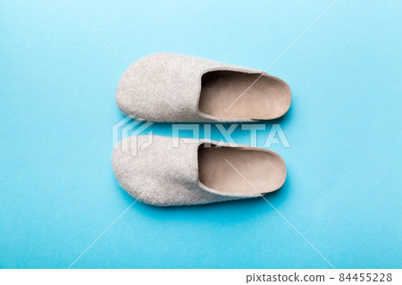 Warm winter women woolen slippers on colored background. Copy space for text 84455228