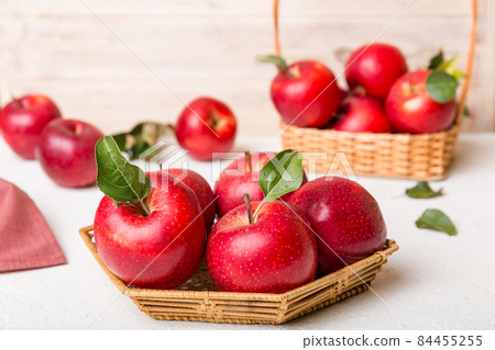 Ripe garden apple fruits with leaves in basket on wooden table. Top view flat lay with copy space Ripe garden apple fruits with leaves in basket on wooden table. Top view flat lay with copy space 84455255