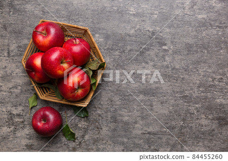 Ripe garden apple fruits with leaves in basket on wooden table. Top view flat lay with copy space Ripe garden apple fruits with leaves in basket on wooden table. Top view flat lay with copy space 84455260