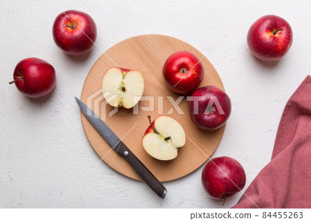 Fresh red apples with green leaves on table. cutting board with knife. Top view Fresh red apples with green leaves on table. cutting board with knife. Top view 84455263