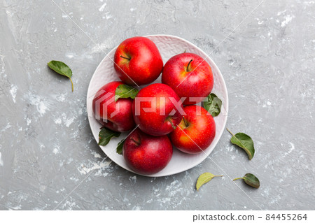 Many red apples on cement background, top view. Autumn pattern with fresh apple above view Many red apples on cement background, top view. Autumn pattern with fresh apple above view 84455264