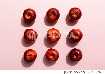 Many red apples on colored background, top view. Autumn pattern with fresh apple above view Many red apples on colored background, top view. Autumn pattern with fresh apple above view 84455265