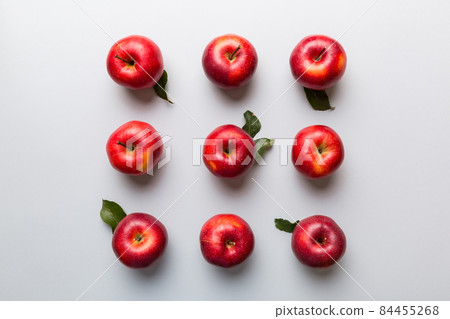 Many red apples on colored background, top view. Autumn pattern with fresh apple above view with copy space for design or text Many red apples on colored background, top view. Autumn pattern with fresh apple above view with copy space for design or text 84455268