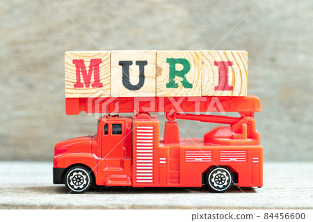 Fire ladder truck hold letter block in word muri on wood background 84456600