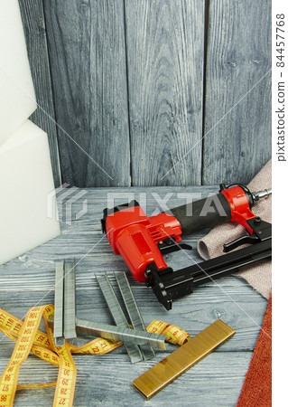 concept of furniture production and repair. Stapler and staples, working tool 84457768