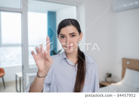 Calm lady pointing up with a forefinger 84457952