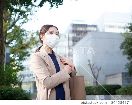[Urban] A woman wearing a mask in the town 84458427