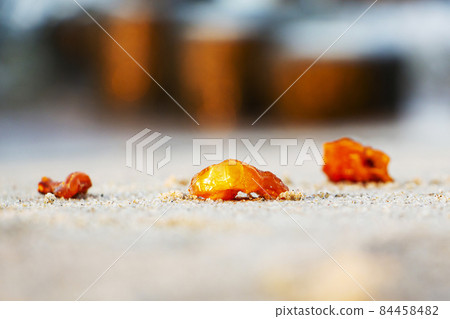 Amber on fine sand, beautiful piece of amber from the sand. Amber on fine sand, beautiful piece of amber from the sand. 84458482