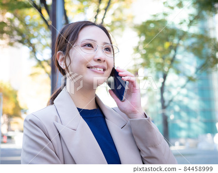 [Urban] A woman calling on her smartphone in the town 84458999