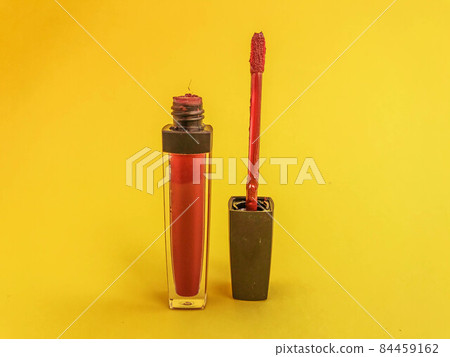 bright matte lip gloss on a yellow matte background. tube with red, berry lipstick. comfortable brush, soft texture for lips, bright shade, fashionable lipstick bright matte lip gloss on a yellow matte background. tube with red, berry lipstick. comfortable brush, soft texture for lips, bright shade, fashionable lipstick 84459162