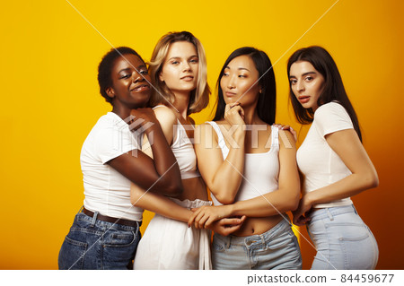 diverse multi nation girls group, teenage friends company cheerful having fun, happy smiling, cute posing on yellow background, lifestyle people concept, african-american, asian and caucasian 84459677