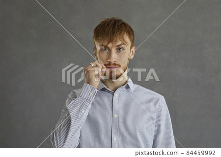 Young caucasian casual red-haired man showing mouth with zipper secret sign studio portrait headshot on grey background. Keep silent gesture people emotion and expression and confidentiality Young caucasian casual red-haired man showing mouth with zipper secret sign studio portrait headshot on grey background. Keep silent gesture people emotion and expression and confidentiality 84459992