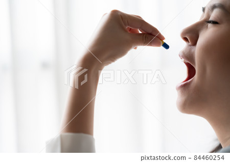 woman taking capsule woman taking capsule 84460254