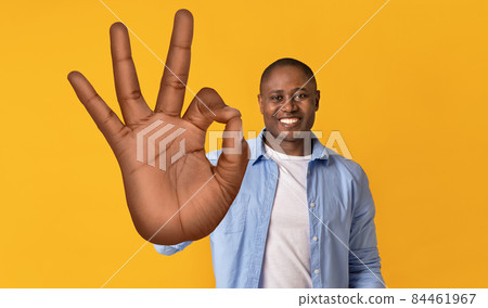 Smiling African American man showing okay gesture, approving or recommending something on orange background 84461967