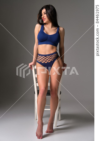 Full length studio shot of a hot brunette woman in a sexy lingerie posing on a gray background. 84461975